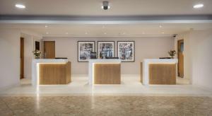 a lobby with two tables and two pictures on the wall at Hilton London Watford in Watford