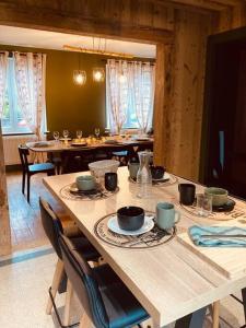 un comedor con mesas de madera y sillas con gafas en Maison Les Planches, en Gérardmer