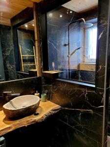a bathroom with a stone sink and a mirror at Maison Les Planches in Gérardmer