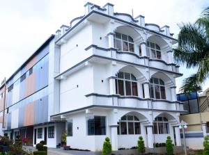 a white building with a lot of windows at Sanjose Residency in Virajpet