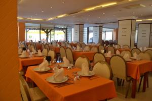 a banquet hall with orange tables and chairs at Admiral Hotel in Kizkalesi