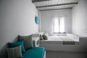a small bedroom with a bed and a window at Drimoni Boutique in Ios Chora