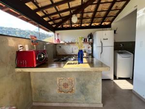 a kitchen with a counter with a microwave and a refrigerator at Casa Cambuí Hospedagem Rural in Rio Prêto +50 photos