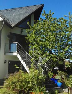 uma casa com uma escada em frente a uma casa em Ferienwohnung im Naturgarten em Chemnitz