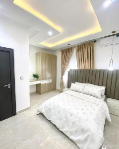 - une chambre avec un grand lit blanc dans l'établissement Taohomes katampe extension, à Kado