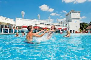 a man and woman playing in the water at a swimming pool at Sea Breeze Cabin in Poole