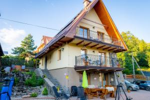 Cette maison dispose d'un balcon et d'une table. dans l'établissement Bylinkowa Chata Jacuzzi & Sauna, à Poronin
