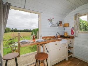 a kitchen with a counter with a sink and a window at Flora's Hut in Liskeard