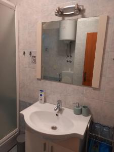 a bathroom with a sink and a mirror at Apartman Dani in Dražice