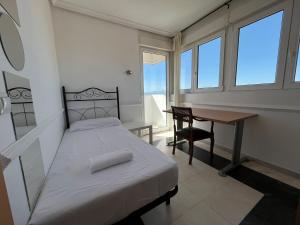 sypialnia z łóżkiem, biurkiem i oknami w obiekcie Pisos con piscina de temporada corta estancia w Madrycie +37 zdjęć