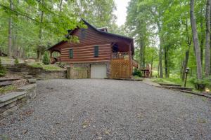 ein Haus mit Garage in der Mitte einer Auffahrt in der Unterkunft Gorgeous Log Cabin with 2 Decks and Fireplaces! in Fleetwood