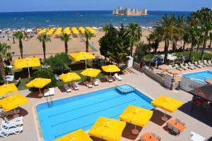 an overhead view of a swimming pool with umbrellas and a beach at Admiral Hotel in Kizkalesi