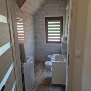 a bathroom with a toilet and a sink at Markowe Domki in Ryn +9 photos