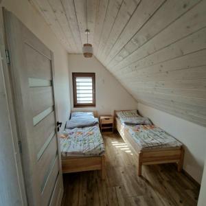 two twin beds in a room with a door at Markowe Domki in Ryn