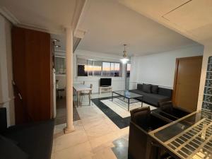 salon z kanapą i stołem w obiekcie Pisos con piscina de temporada corta estancia w Madrycie