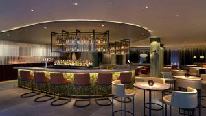 un bar en un hotel con sillas y mesas en Hilton Woking, en Woking
