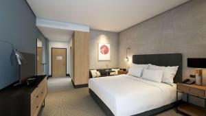 una camera da letto con un grande letto bianco e una televisione di Hilton Woking a Woking