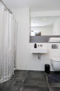 a bathroom with a shower and a toilet and a sink at Charming 3-Bed Apartment in London in London