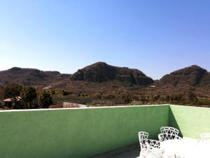 MorelosにあるBungalows Boutique Tonantzinの山々を背景に椅子2脚を配した緑の壁