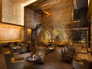 北京的住宿－北京康萊德酒店 - 希爾頓集團，一间带桌椅的餐厅以及一堵树墙