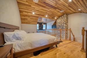 1 dormitorio con cama y techo de madera en The Haüs Windham, en Windham