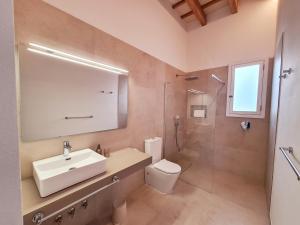 a bathroom with a sink and a toilet and a shower at Waki Conscious Hotel in Ciutadella