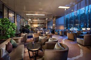 a lobby of a hotel with chairs and tables at Hilton Guangzhou Tianhe in Guangzhou