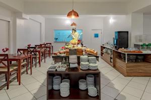 a restaurant with tables and chairs and a buffet at Bristol Sabrina Hotel de Charme Joinville in Joinville