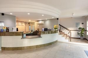 eine Lobby eines Hotels mit einem Wartebereich und einer Theke in der Unterkunft Bristol Sabrina Hotel de Charme Joinville in Joinville