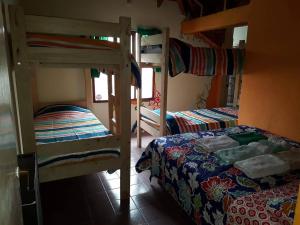 a room with two bunk beds and a bed at Hostel Huellas Patagonicas in Junín de los Andes