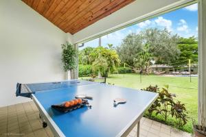 une table de ping-pong bleue dans une pièce avec une grande fenêtre dans l'établissement Luxe Retreat with Private Beach & Pool Paradise L53, à Miami