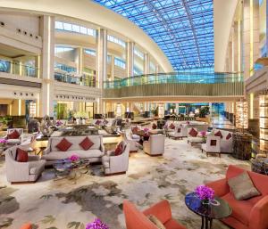 a lobby with couches and tables in a building at Hilton Guangzhou Science City, Free Shuttle Bus to Canton Fair in Guangzhou