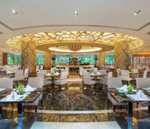 a restaurant with tables and chairs and a bar at Hilton Guangzhou Science City, Free Shuttle Bus to Canton Fair in Guangzhou