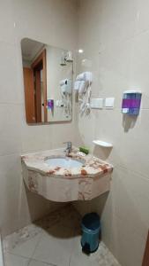 a bathroom with a marble sink and a mirror at Luluat Al sharq Al Awsat in Makkah