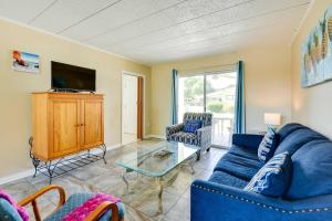 a living room with a blue couch and a tv at Sunny Florida Condo 4 Mi to Gulf Islands Seashore in Fort Walton Beach
