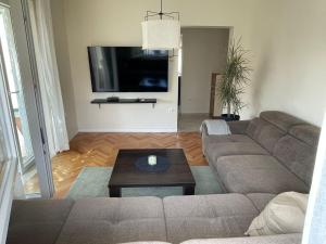 a living room with a couch and a flat screen tv at Apartman Maja in Vodice