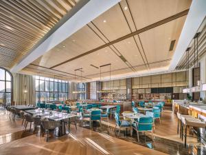 a dining room with tables and chairs and windows at Doubletree By Hilton Yingde Resort in Yingde