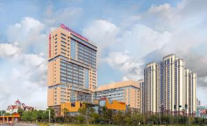 Un palazzo alto con un cartello sopra. di Hilton Garden Inn Changde Dingcheng a Changde