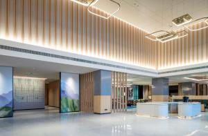 un vestíbulo de oficina con recepción y paneles de madera en Hilton Garden Inn Changde Dingcheng, en Changde