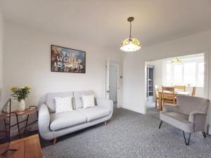 a living room with a couch and chairs and a table at Entire 3 bedroom house 5 minutes from the beach in Kent