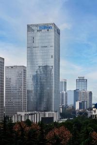 a tall glass building in a large city at Hilton Chongqing Liangjiang New Area in Chongqing