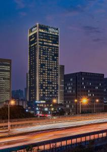 un edificio alto en una ciudad por la noche en Hilton Chongqing Liangjiang New Area en Chongqing
