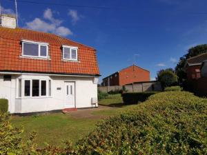 ein weißes Haus mit orangefarbenem Dach in der Unterkunft Entire 3 bedroom house 5 minutes from the beach in Kent