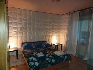 a bedroom with a bed with two lamps on two tables at Mona Apartments in Skopje