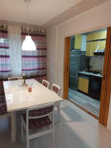 a kitchen with a white table and a kitchen with yellow cabinets at Mona Apartments in Skopje