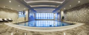 a large swimming pool in a building with a lobby at DoubleTree by Hilton Chongqing North in Chongqing