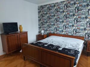 a bedroom with a bed and a wall with a wallpaper at Mona Apartments in Skopje