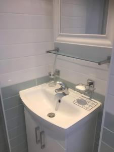 bagno bianco con lavandino e specchio di Edina place -Lovely central one bedroom apartment a Edimburgo