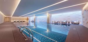 una gran piscina con sillas en un edificio en Hilton Chengdu Chenghua en Chengdú