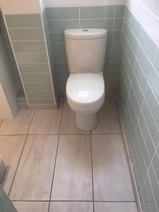 bagno con servizi igienici bianchi e pavimenti piastrellati. di Edina place -Lovely central one bedroom apartment a Edimburgo